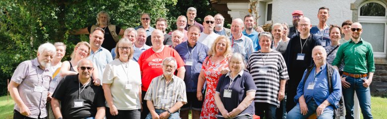 Eine Gruppe Teilnehmende steht vor dem DGB Tagungszentrum für ein Gruppenbild.