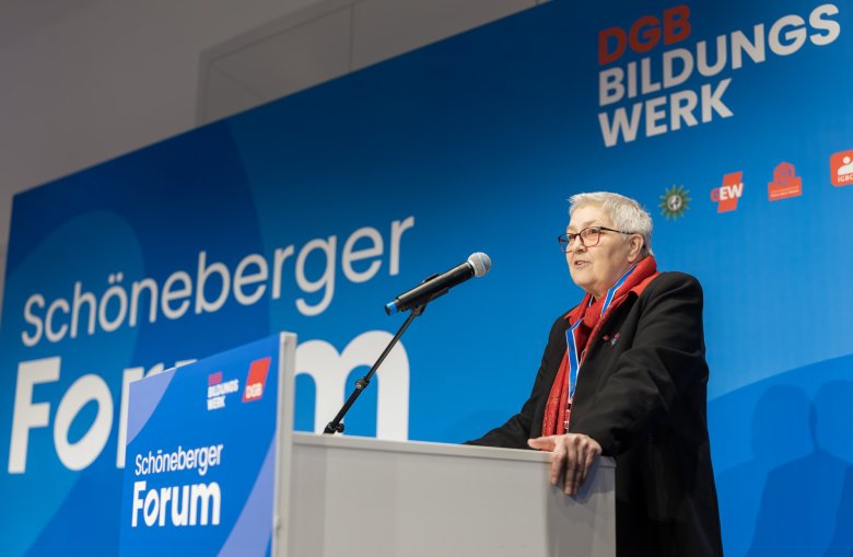 Frau am Rednerpult vor blauer Rückwand mit Schriftzug Schöneberger Forum