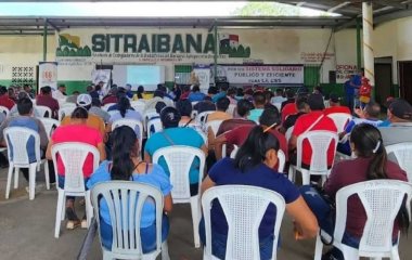 Arbeiter*innen der Bananengewerkschaften haben sich versammelt. Man sieht sie von hinten auf Stühlen sitzen und im Hintergrund auf dem Gebäude steht ein Schriftzug mit dem Namen der Gewerkschaft: SITRAIBANA